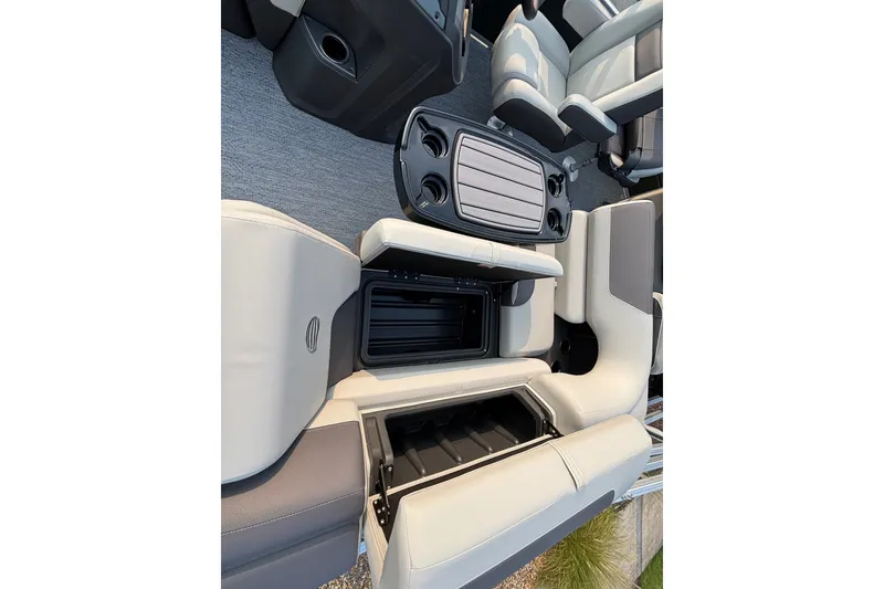 Slide: The Image of 2027 Sun Tracker Fishin' Barge 20 DLX interior seating with storage compartments and cup holders. - 18