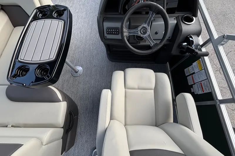 Slide: The Image of 2027 Sun Tracker Fishin' Barge 20 DLX interior with steering wheel and seating. - 16