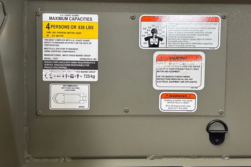 Slide: The Image of 2027 Tracker Grizzly 1553 Timber capacity and safety warning labels on interior panel. - 21