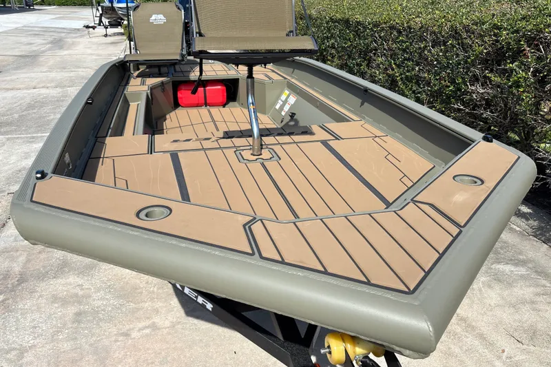 Slide: The Image of 2027 Tracker Grizzly 1553 Timber boat with tan deck, outdoor setting. - 13