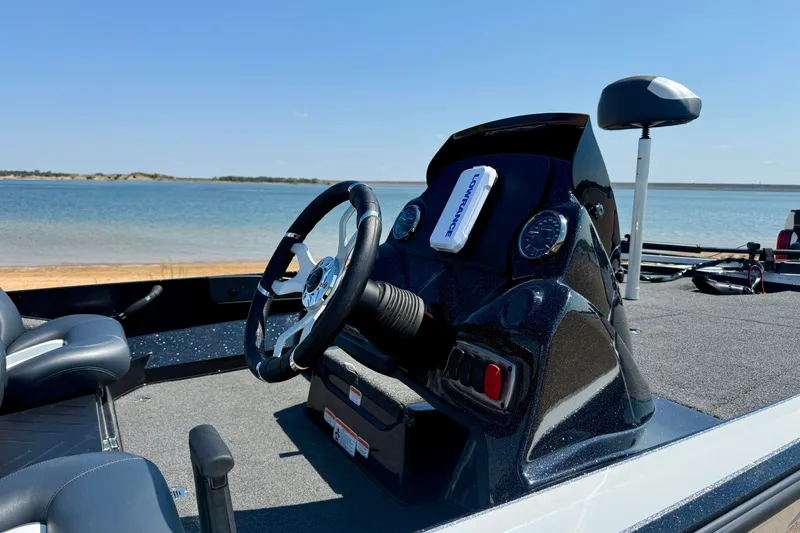 Slide: The Image of Nitro Z17 2027 boat dashboard with steering wheel, near a serene lake. - 4