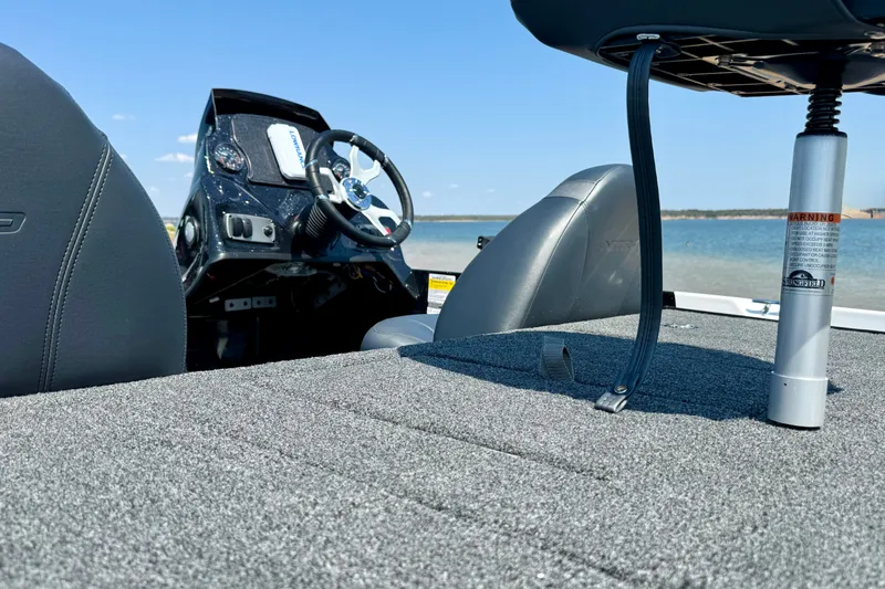 Slide: The Image of Interior of a 2027 Nitro Z17 boat with steering wheel and seating, overlooking a lake. - 12