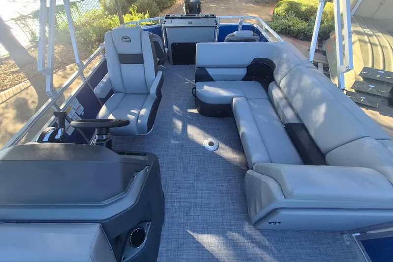 Slide: The Image of 2027 Sun Tracker SportFish 20 DLX pontoon boat interior with plush seating and steering console. - 14