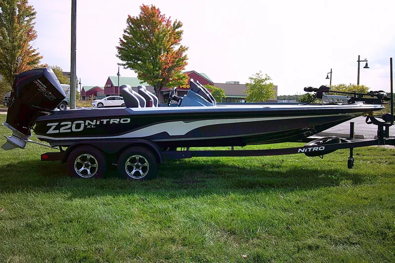 Slide: The Image of 2025 Nitro Z20 XL Pro boat on trailer, parked on grass with trees and buildings in background. - 3