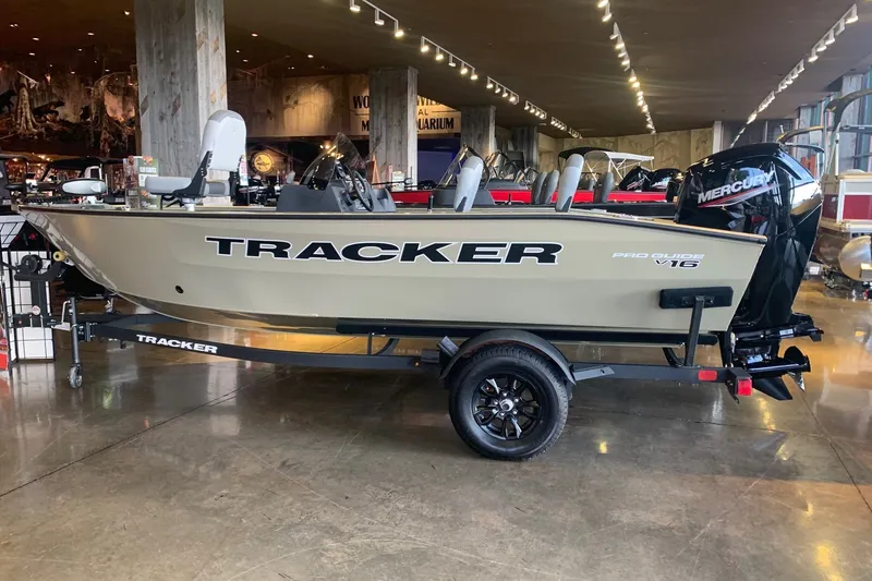 The Image of 2027 Tracker Pro Guide V-16 SC boat displayed indoors on a trailer. - 0