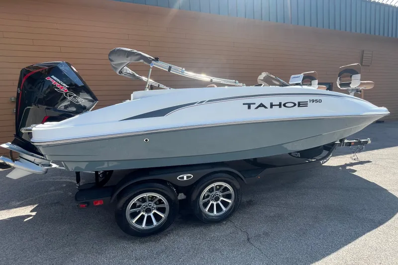 Slide: The Image of 2027 Tahoe 1950 boat on trailer, sleek design, parked outdoors in sunlight. - 1
