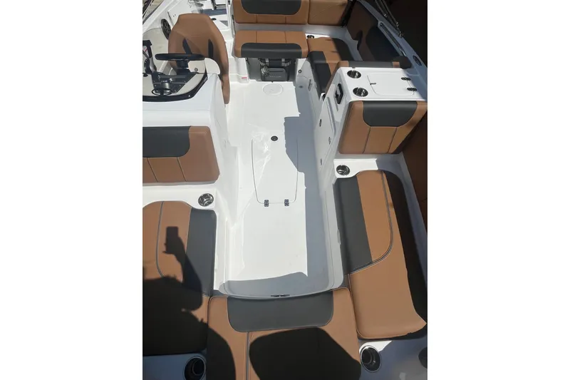 Slide: The Image of 2027 Tahoe 1950 boat interior with brown and black seating, white deck, and steering console. - 8