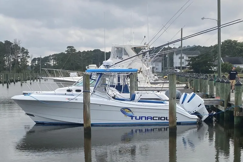 The Image of 2000 Hydra-Sports boat named "Tunacious" docked at a marina under cloudy skies. - 2