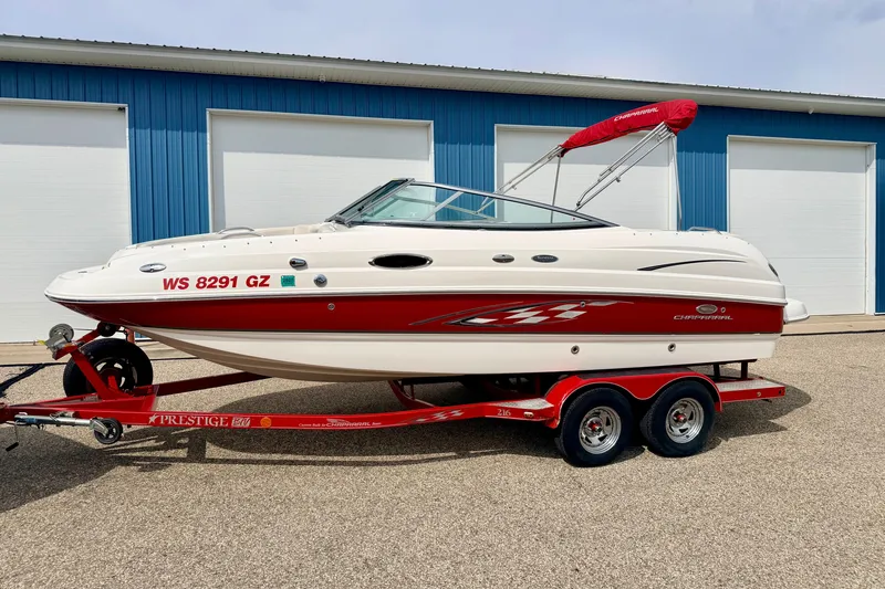 Slide: The Image of 2006 Chaparral Sunesta 216 boat on red trailer, parked near blue building. - 1