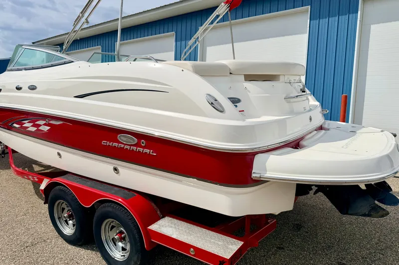 Slide: The Image of 2006 Chaparral Sunesta 216 boat on red trailer, parked near blue building. - 13