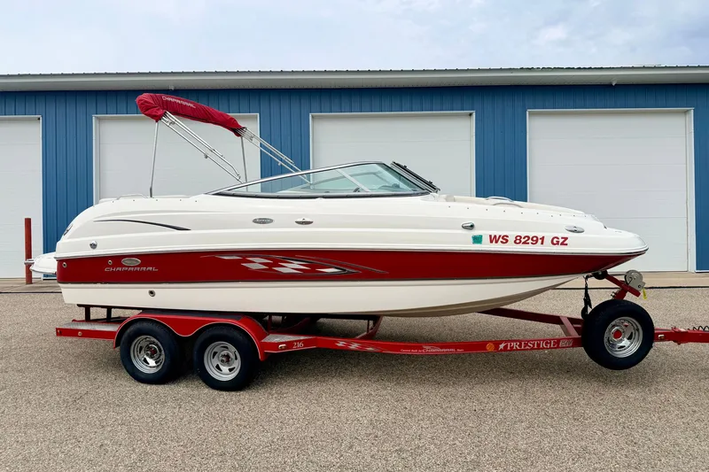 Slide: The Image of 2006 Chaparral Sunesta 216 boat on red trailer, parked near blue building. - 2