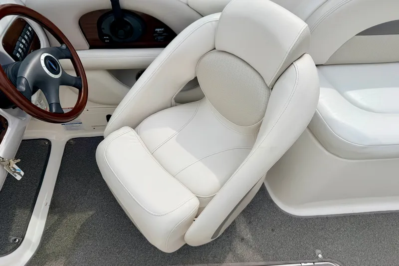 Slide: The Image of 2006 Chaparral Sunesta 216 boat interior with white captain's chair and steering wheel. - 46