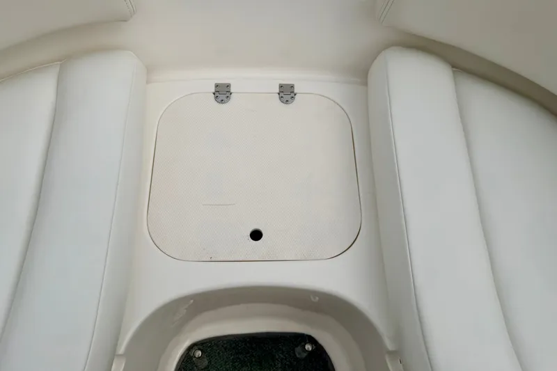 Slide: The Image of 2006 Chaparral Sunesta 216 boat interior with white seating and storage compartment. - 68