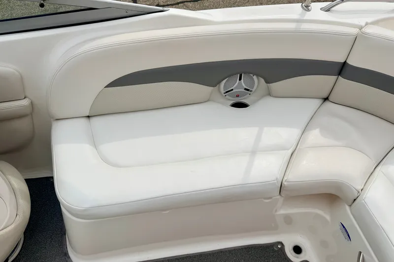 Slide: The Image of 2006 Chaparral Sunesta 216 boat interior with white cushioned seating and speaker. - 29