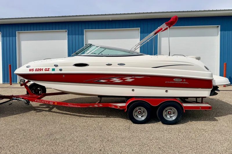 Slide: The Image of 2006 Chaparral Sunesta 216 boat on red trailer, parked near blue building. - 3