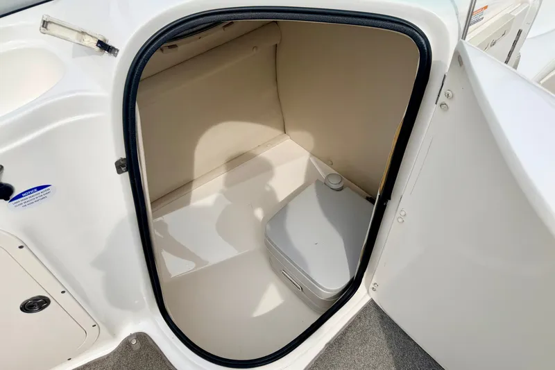 Slide: The Image of 2006 Chaparral Sunesta 216 boat interior storage compartment with portable toilet. - 44