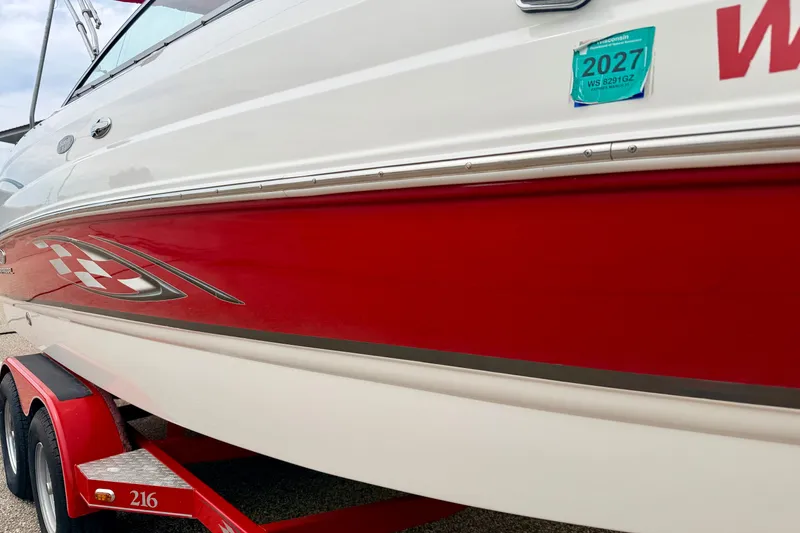 Slide: The Image of 2006 Chaparral Sunesta 216 boat with red and white design on trailer. - 14