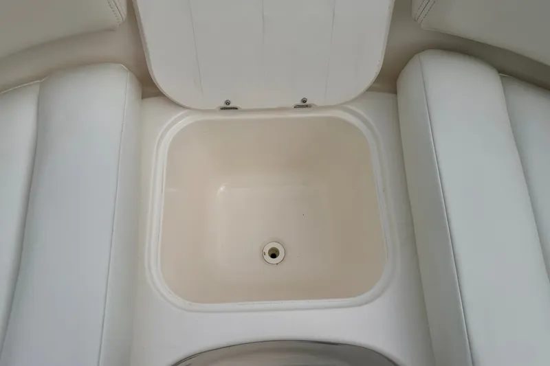 Slide: The Image of Storage compartment in 2006 Chaparral Sunesta 216 boat, featuring white cushioned seating. - 69
