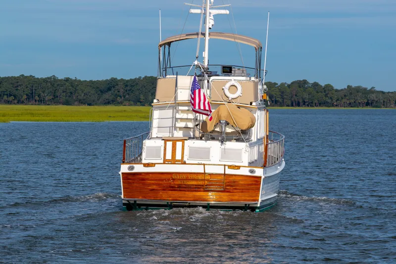 Slide: The Image of Grand Banks 46 Classic yacht cruising on a serene waterway, 1998 model. - 94