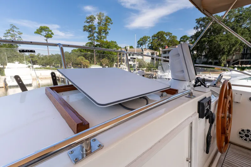 Slide: The Image of 1998 Grand Banks 46 Classic yacht helm with modern navigation equipment and scenic marina view. - 78