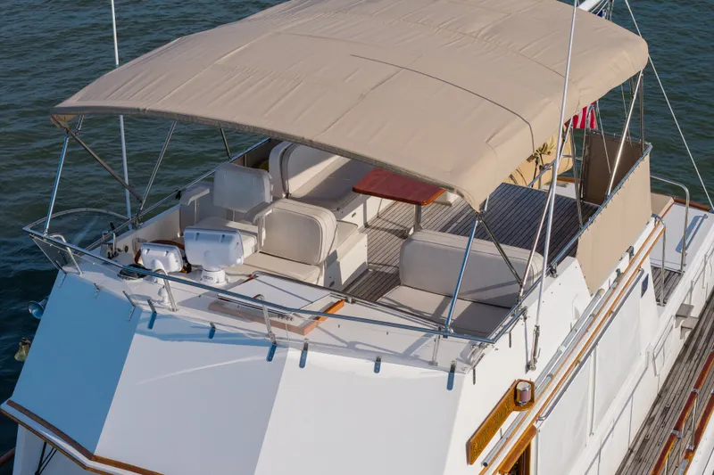 Slide: The Image of 1998 Grand Banks 46 Classic yacht with spacious flybridge and canopy on water. - 103