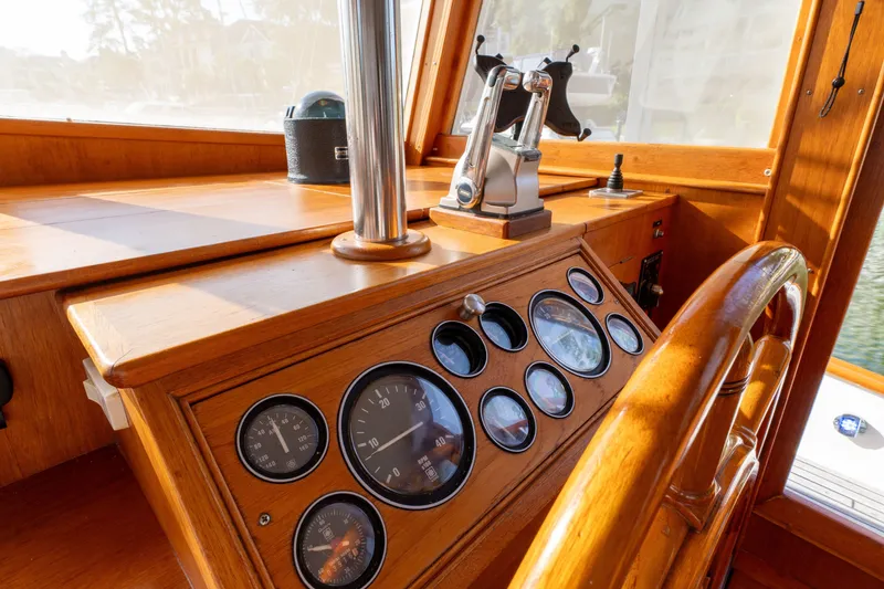 Slide: The Image of Helm of 1998 Grand Banks 46 Classic yacht with wooden dashboard and gauges. - 24