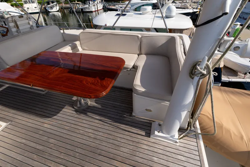Slide: The Image of 1998 Grand Banks 46 Classic yacht with elegant wooden table and cushioned seating on deck. - 73