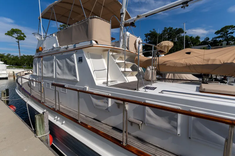 Slide: The Image of 1998 Grand Banks 46 Classic yacht docked, featuring elegant design and spacious deck. - 9