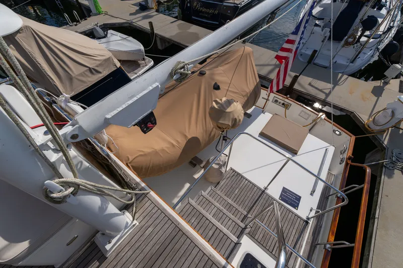 Slide: The Image of 1998 Grand Banks 46 Classic yacht docked, featuring covered deck and American flag. - 72