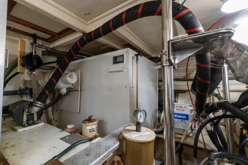 Slide: The Image of Engine room of 1998 Grand Banks 46 Classic yacht, featuring mechanical components and piping. - 57