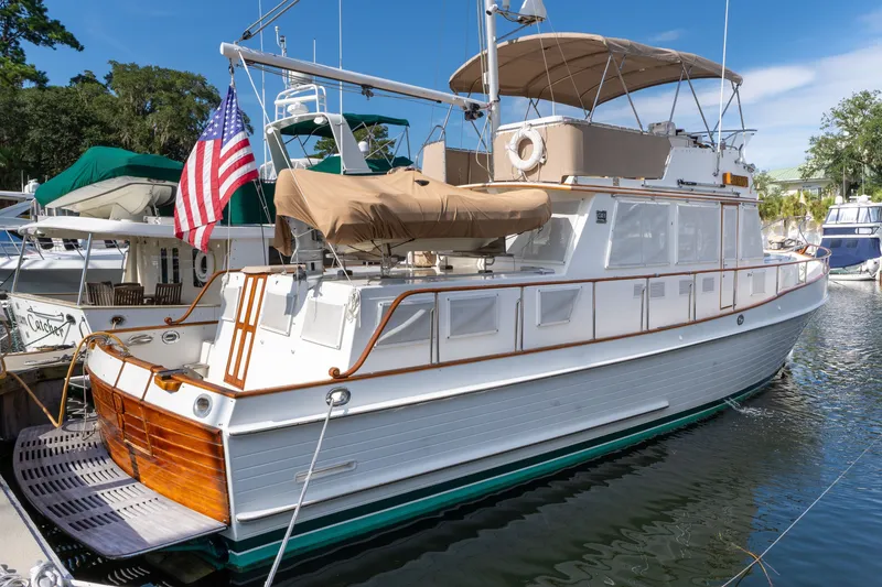 Slide: The Image of 1998 Grand Banks 46 Classic yacht docked, featuring elegant design and American flag. - 88