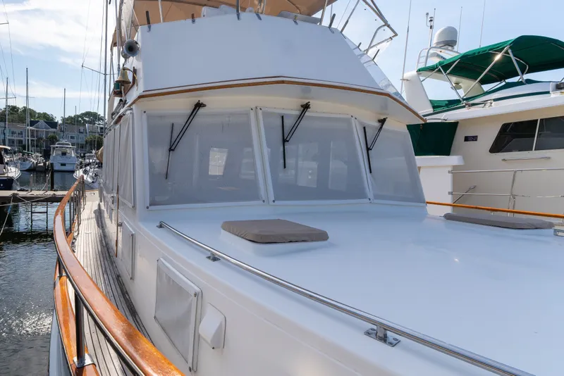 Slide: The Image of 1998 Grand Banks 46 Classic yacht docked at marina, showcasing sleek design and spacious deck. - 86