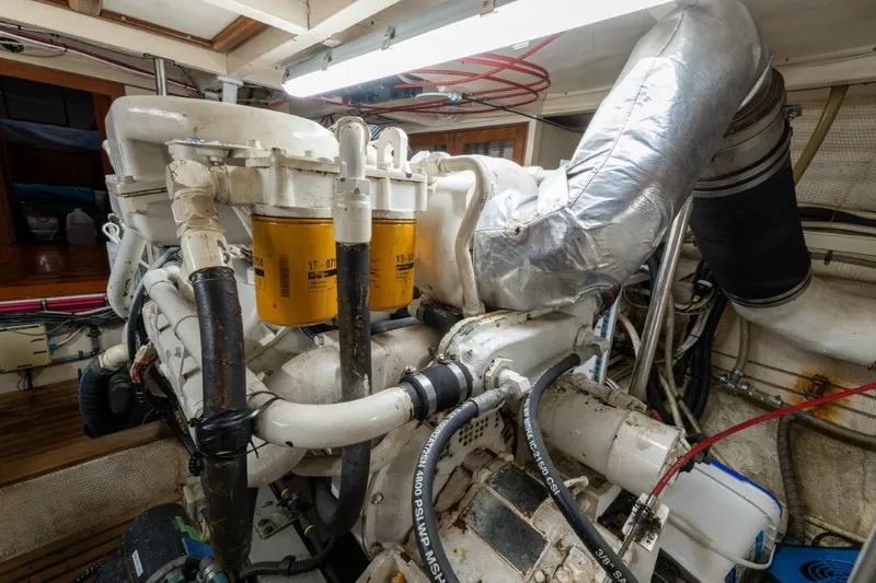 Slide: The Image of Engine room of a 1998 Grand Banks 46 Classic yacht, showcasing mechanical components. - 54