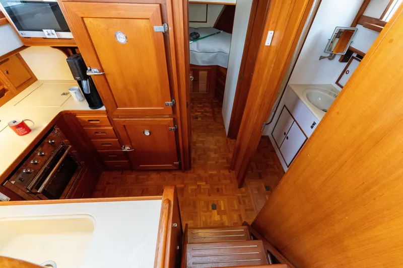 Slide: The Image of Interior of 1998 Grand Banks 46 Classic yacht, featuring wooden cabinetry and compact kitchen area. - 30