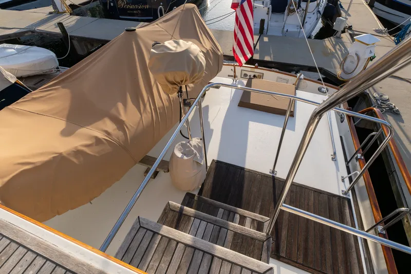 Slide: The Image of 1998 Grand Banks 46 Classic yacht deck with covered equipment and American flag. - 67