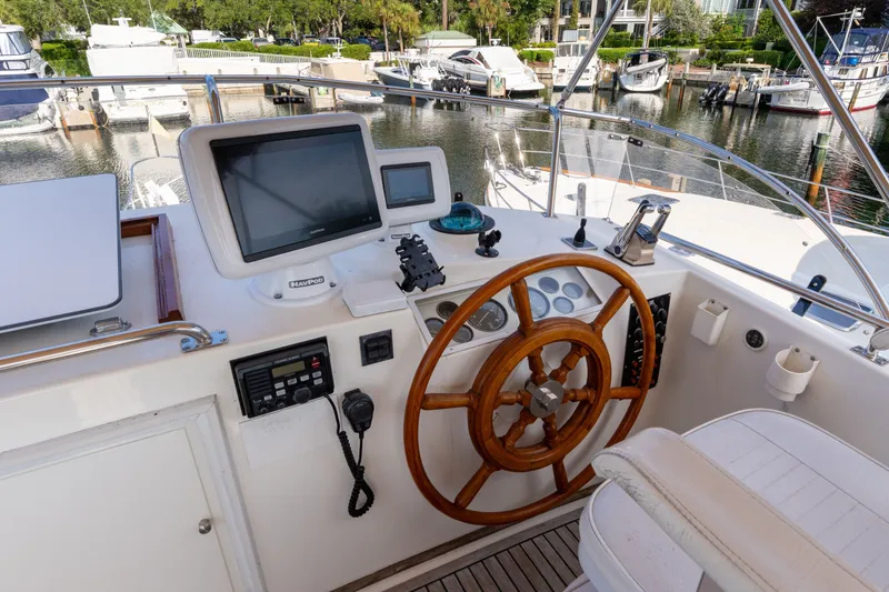 Slide: The Image of Helm of 1998 Grand Banks 46 Classic yacht with navigation equipment and wooden steering wheel. - 76