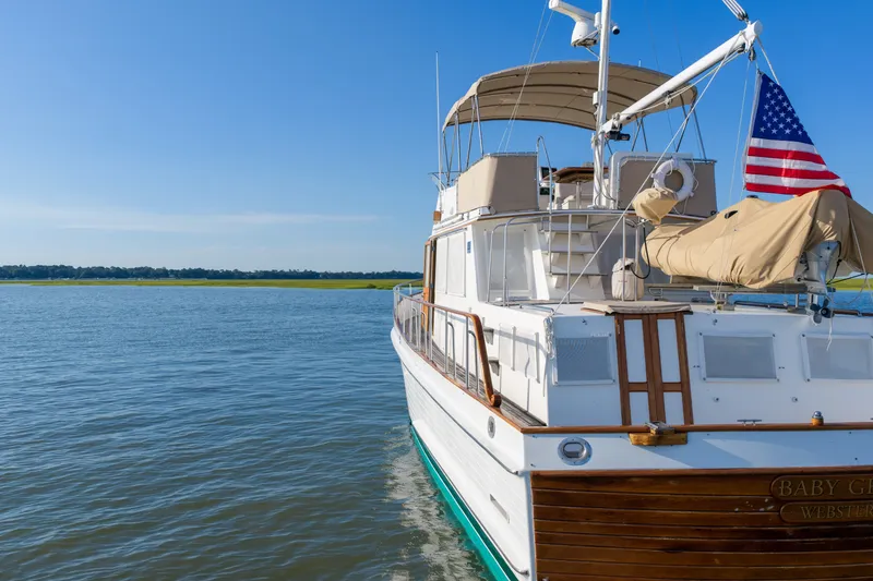 Slide: The Image of Grand Banks 46 Classic yacht, 1998 model, anchored on calm waters under clear blue sky. - 102