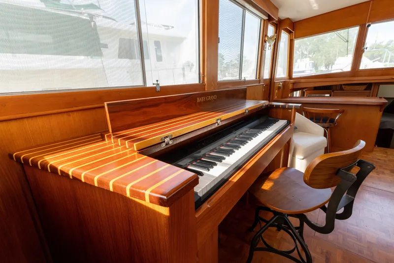 Slide: The Image of Luxurious 1998 Grand Banks 46 Classic yacht interior with a wooden piano and seating area. - 12
