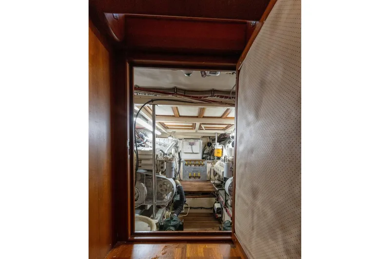 Slide: The Image of Engine room of 1998 Grand Banks 46 Classic yacht, showcasing mechanical equipment and wooden interior. - 53