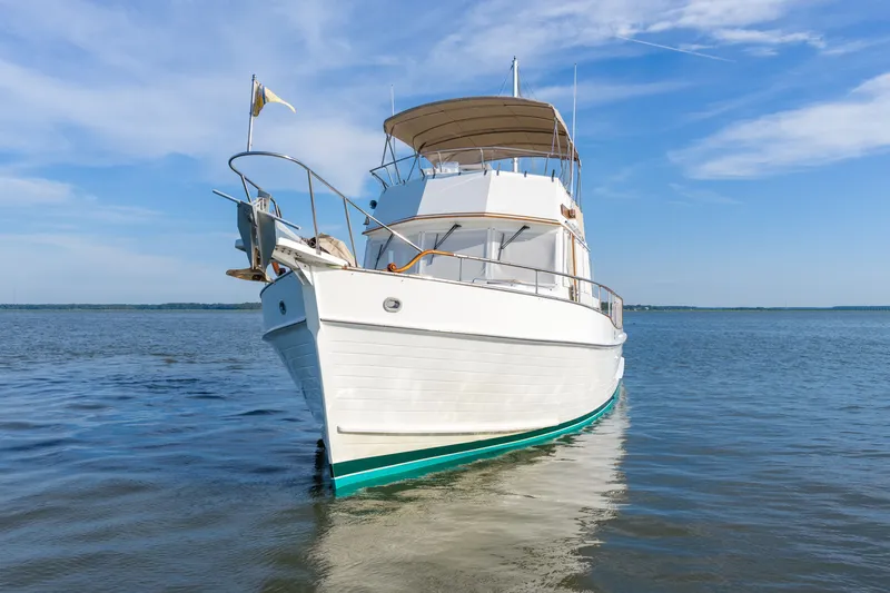 Slide: The Image of Grand Banks 46 Classic yacht from 1998 on calm water under blue sky. - 2
