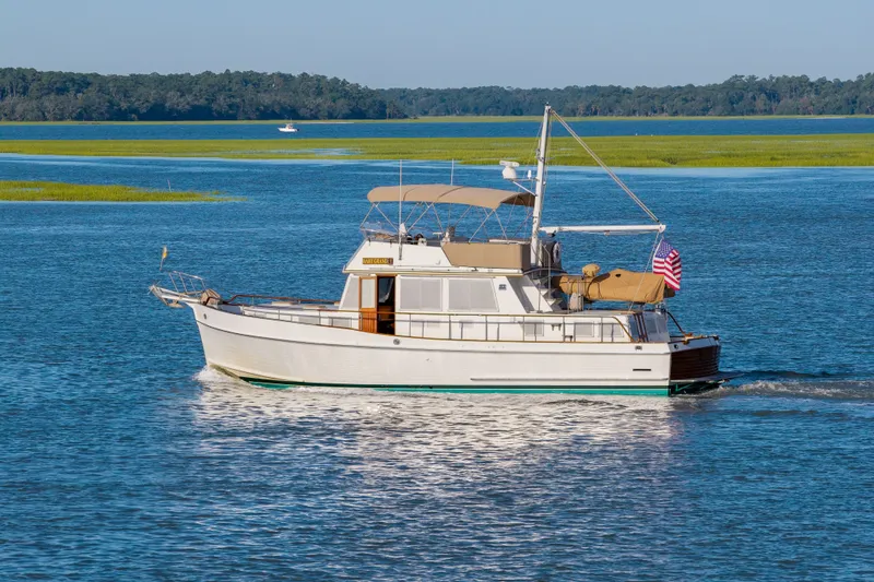 Slide: The Image of Grand Banks 46 Classic yacht cruising on a serene blue lake, 1998 model. - 3