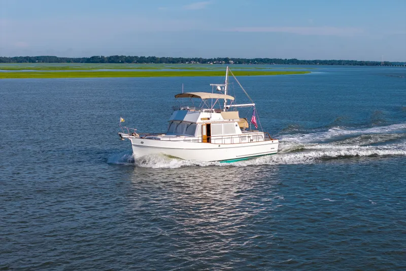 Slide: The Image of 1998 Grand Banks 46 Classic yacht cruising on a serene blue lake. - 5