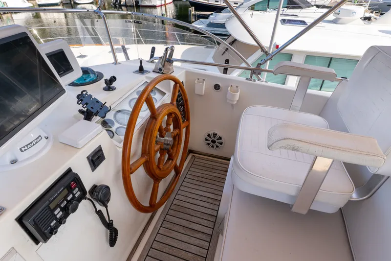 Slide: The Image of Helm of 1998 Grand Banks 46 Classic yacht with wooden wheel and navigation equipment. - 77