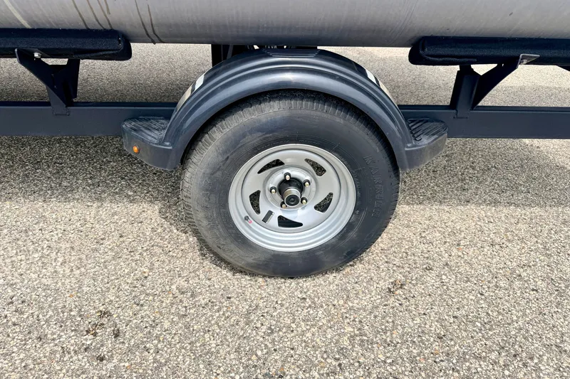 Slide: The Image of Trailer wheel of 2022 Sun Tracker Bass Buggy 18 DLX on asphalt surface. - 75