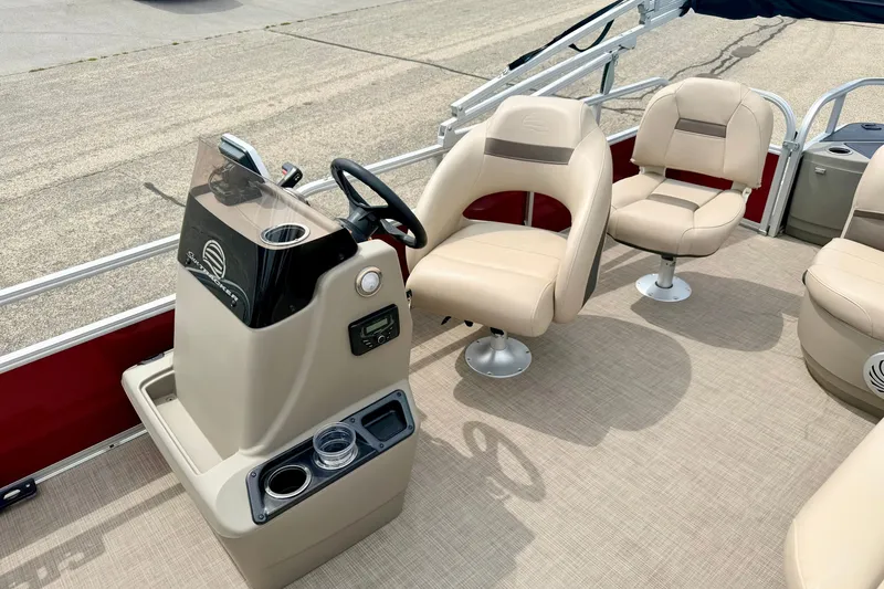 Slide: The Image of 2022 Sun Tracker Bass Buggy 18 DLX interior with beige seating and steering console. - 50