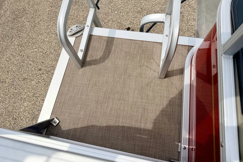 Slide: The Image of 2022 Sun Tracker Bass Buggy 18 DLX boat deck with ladder and textured flooring. - 22