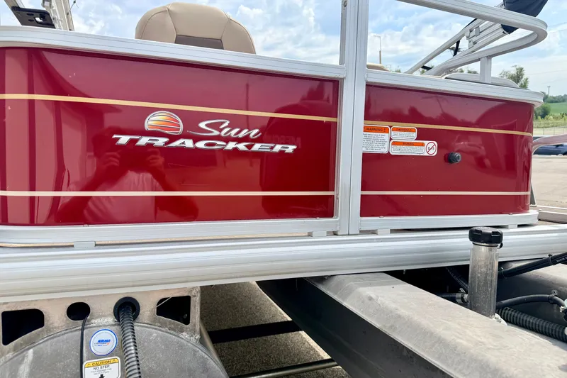 Slide: The Image of 2022 Sun Tracker Bass Buggy 18 DLX pontoon boat with red exterior detailing. - 18