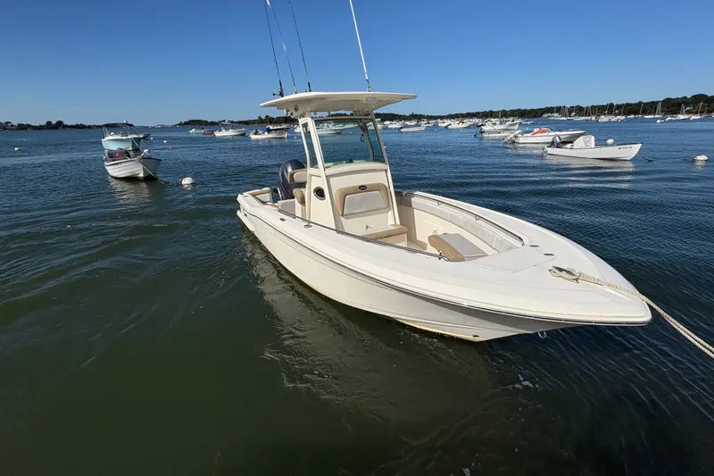 Slide: The Image of 2014 Scout 225 XSF boat anchored in a calm bay with other boats. - 5
