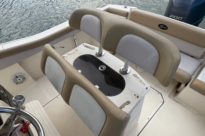 Slide: The Image of 2014 Scout 225 XSF boat interior with seating and steering wheel, near water. - 17