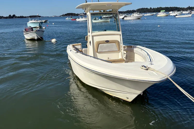 Slide: The Image of 2014 Scout 225 XSF boat moored on calm water with other boats nearby. - 4